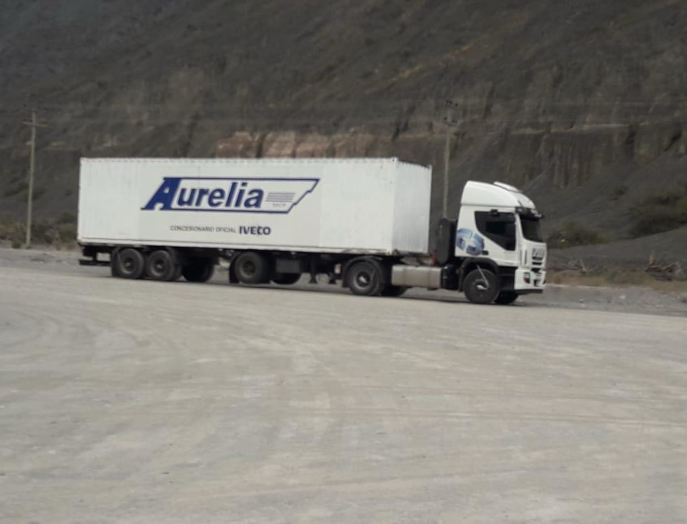 Camión marca IVECO blanco de carga de la empresa Bonsur, estacionado en un área desértica